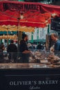 Seller and customer at Olivers Bakery stall at Borough Market, London, UK