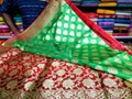 A seller displaying Indian sari in a clothing store