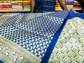 A seller displaying Indian sari in a clothing store