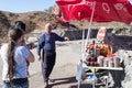 The seller - druz stands with the customer and offers the goods, near his shop with canned sweets in the parking lot, on Mount Ben Royalty Free Stock Photo