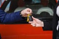 The seller hands over the car keys to the buyer