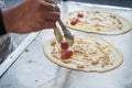 Seller making Khanom Tokyo thin flat pancake Thai street snack