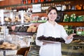 Seller offering tray of cakes