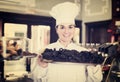 Seller offering tray of cakes