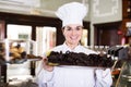 Seller offering tray of cakes