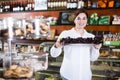 Seller offering tray of cakes