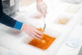 Seller putting caviar into a jar at shop