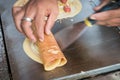 Seller rolling Khanom Tokyo thin flat pancake Thai street snack Royalty Free Stock Photo