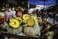 A seller is selling pumpkins that have been cut into half at the Ban Na Kluea Folk Market, Pattaya, Thailand Royalty Free Stock Photo