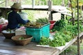 Seller sits on wooden floor and sells the organic vegetable and food