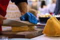 Seller slicing cheese on wooden board. Cheese shop Royalty Free Stock Photo