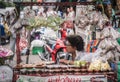 A seller of sour fruit in a plastic bag sits and waits for customers to buy it in Bangkok.