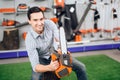 The seller in the store shows the customers a chainsaw. Royalty Free Stock Photo
