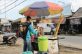 A seller of sugar cane ice preparing a customer\'s order