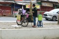 a seller of sugar cane juice drinks on the side of the main road close to the city park