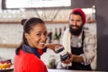 Seller taking payment with bank card reader and smartphone Royalty Free Stock Photo