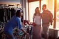 Seller woman to selling happy customers new bicycle in store