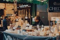 Seller working at a cheese stand in Borough Market, London, UK