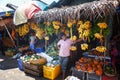 Sellers in street shop sell fresh fruits bananas, papaya and vegetables. Traditional Asian local market Royalty Free Stock Photo
