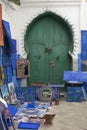 Selling homemade art in front of a historical door in the medina of Asilah