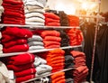 Selling in the store of warm things sweaters and jacket. Fashionable and stylish clothes, a stack of multi-colored