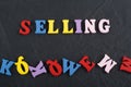 SELLING word on black board background composed from colorful abc alphabet block wooden letters, copy space for ad text. Learning Royalty Free Stock Photo