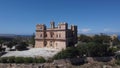 Selmun palace and surrounding farmhouses with Mediterranean sea in the back. Drone orbiting shot