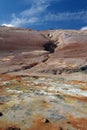 Seltun / Krysuvik KrÃÂ½suvÃÂ­k: View over yellow, orange and white geothermal field on fissure of red hill contrasting with blue Royalty Free Stock Photo