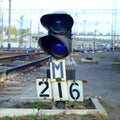 Semaphore with burning blue light. The intersection of railway tracks Royalty Free Stock Photo