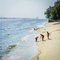 Children searching for seashell beside the beach near Sembawang Park, Singapore.