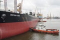 Sembawang, Singapore - March 10 2013: Tugboats assisting crude oil tanker \
