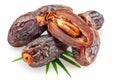 Semi-dried dates and date fruit cut in half lie on palm leaves isolated on white background. File contains clipping path