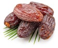 Semi-dried dates or date palm fruits lie on palm leaves isolated on white background. File contains clipping path
