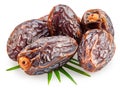 Semi-dried dates or date palm fruits lie on palm leaves isolated on white background. File contains clipping path