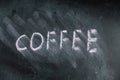 The semi-erased word COFFEE on black chalkboard. Handwritten word. Fuzzy letters on black surface