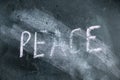 Semi-erased word PEACE on black chalkboard. Handwritten word. Fuzzy letters on black surface