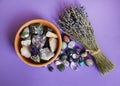 Semi-precious stones in a wooden bowl with a dry lavender bouquet. Amethyst and amethyst druse crystals, rose quartz, agate,