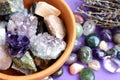 Semi-precious stones in a wooden bowl with a dry lavender bouquet. Amethyst and amethyst druse crystals, rose quartz, agate,