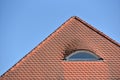 Semi round skylight. Roof covered with tiles and a semicircular window against the blue sky in a European city, with