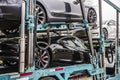 A semi-tracker trailer hauling seven Tesla Models 3 and X, painted white, black and silver, sits parked overnight in a parking lot