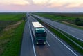 Semi-trailer truck DAF driving along highway on sunset background. Truck convoy or caravan of trucks delivery goods by roads. Royalty Free Stock Photo