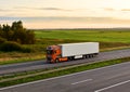 Semi-trailer truck DAF FX EURO 6 driving along highway on sunset background. Out of focus, possible granularity, motion blur. Royalty Free Stock Photo