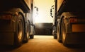 Semi Trailer Trucks Parked Lot at the Warehouse in Sunset. Big Rig Semi Truck Wheels Tires. Shipping Freight Truck Logistics. Royalty Free Stock Photo