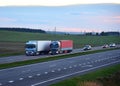 Semi-trailer Trucks Renault and Mercedes-Benz Actros driving on highway. Truck on asphalt road overtakes another truck. Goods