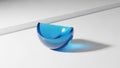 A semi transparent blue crescent shaped object rests on a smooth white Royalty Free Stock Photo
