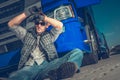 Male Trucker Sitting On Ground At Rest Stop Area Royalty Free Stock Photo