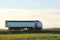 Semi-truck with tipping cargo trailer transporting sand from quarry driving on highway hauling goods in evening Royalty Free Stock Photo