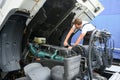 Semi Truck Under Maintenance. Caucasian Truck Mechanic Working to Fix the Tractor. Royalty Free Stock Photo