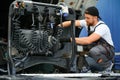 Semi Truck Under Maintenance. Caucasian Truck Mechanic Working to Fix the Tractor. Royalty Free Stock Photo