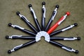 Semicircle of black ballpoint pens with a red one Royalty Free Stock Photo